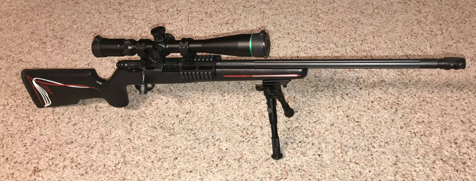 A rifle with a scope on it's stand.