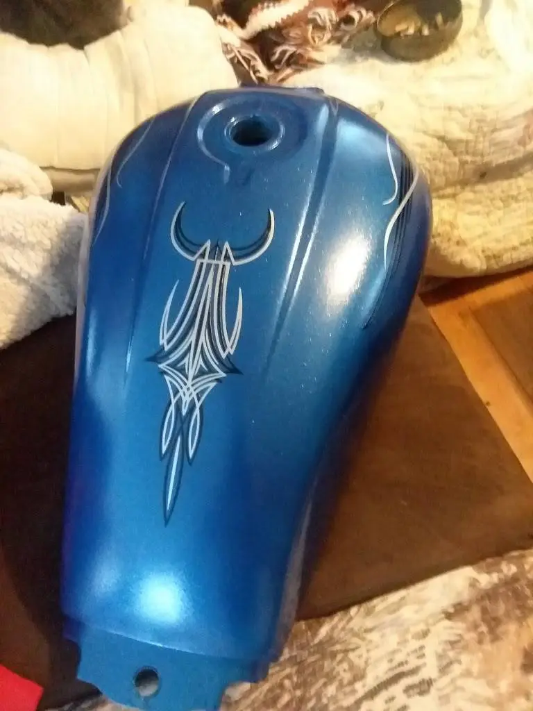 A blue motorcycle seat with an ornate design on it.