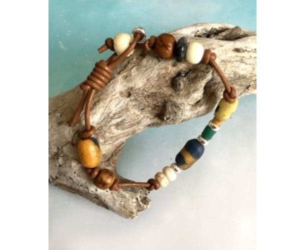A wooden bead bracelet is sitting on top of a tree.