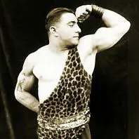 A man in leopard print shirt and shorts flexing his muscles.