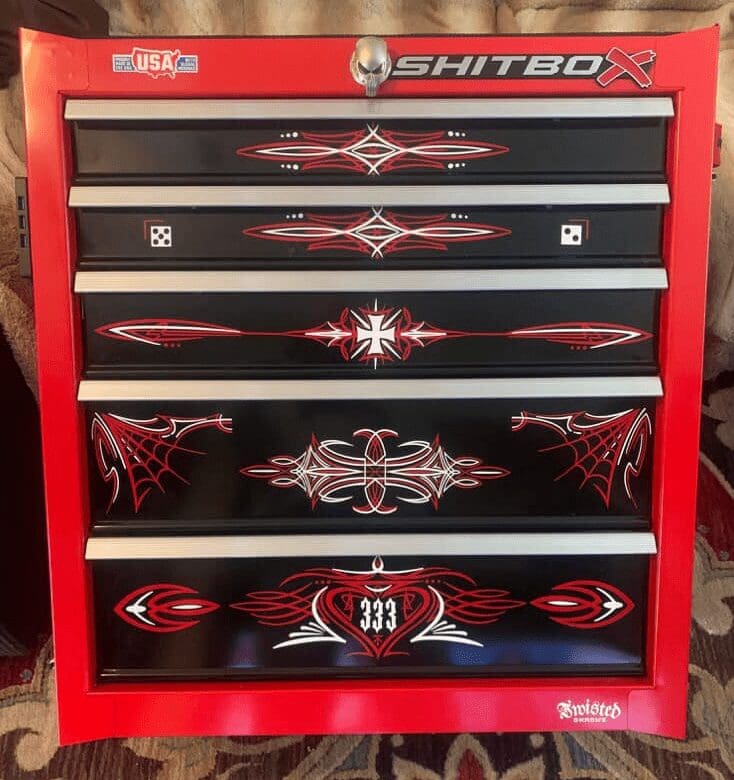 A red and black tool chest with many designs on it.